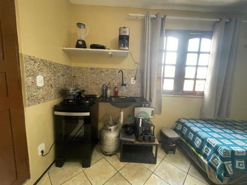 a kitchen with a sink and a bed in a room at Residence Fonteles in Sobral