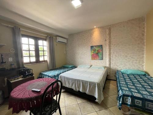 a bedroom with two twin beds and a table at Residence Fonteles in Sobral