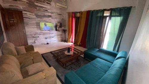 a living room with a blue couch and a living room withwindows at Dakar Mermoz mz52 in Dakar
