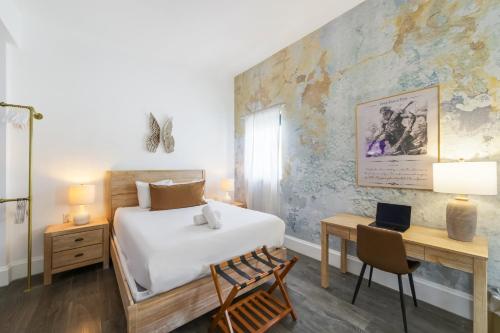 una camera da letto con un letto e una scrivania con una sedia di Ithaca a Miami Beach