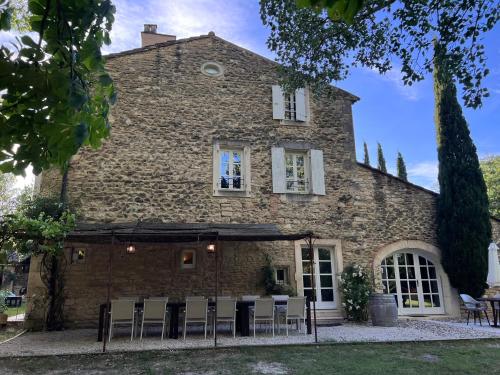a stone house with chairs in front of it at Le Moulin de Montségur in Montségur-sur-Lauzon