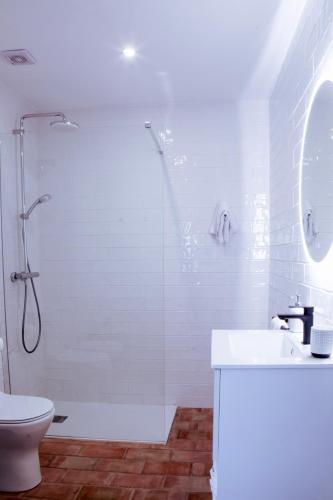 a white bathroom with a shower and a sink at Mar-Ria 4 in Fuzeta