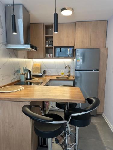 a kitchen with a wooden counter and a refrigerator at Mono Ambiente POCITOS NUEVO in Montevideo