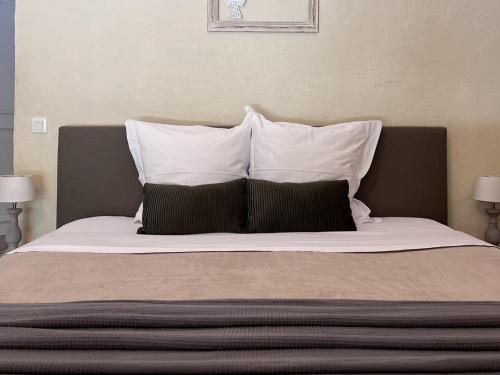 a large bed with three pillows at Le Moulin de Montségur in Montségur-sur-Lauzon