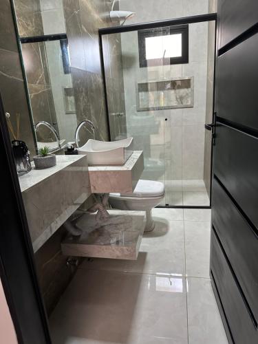 a bathroom with a sink and a toilet at Casa Frente ao Lago com Piscina Aquecida no Melhor Condomínio in Abadiânia
