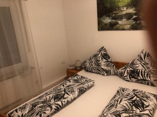 a bed with black and white pillows on it at Ferienwohnung 2Doppel 1 Einzel Bett in Siegen