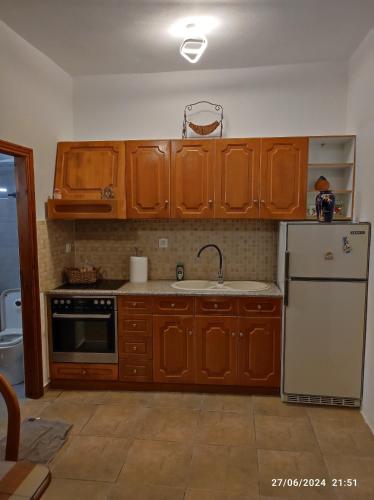 a kitchen with wooden cabinets and a white refrigerator at The View House 3 in Kithnos