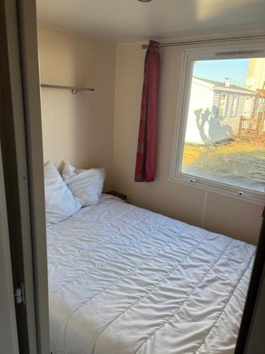 une petite chambre avec un lit et une fenêtre dans l'établissement Camping La plage, à Saint-Hilaire-de-Riez