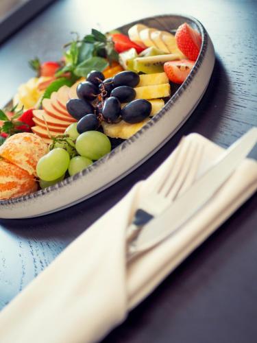 a plate of fruit and vegetables on a table at Hotel Moskva in Budva