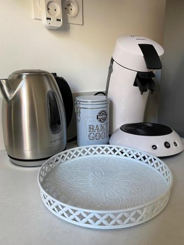 - un comptoir de cuisine avec une cafetière et une plaque de cuisson dans l'établissement 2 pièces élégant calme central parking sur place, à Foix