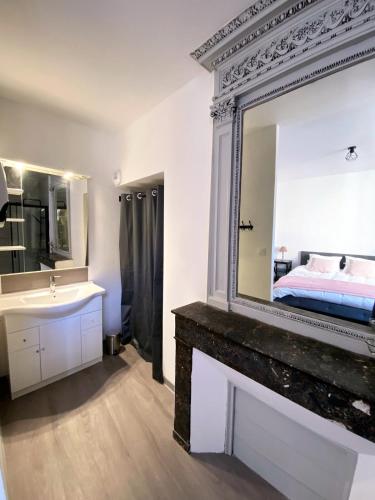 a bathroom with a mirror and a sink and a bed at 2 pièces élégant calme central parking sur place in Foix