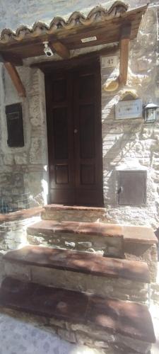 a stone building with a wooden door and stairs at Cottanello,"La casa del sole" in Cottanello