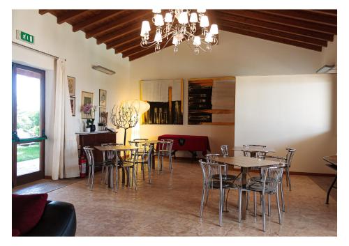 a dining room with tables and chairs and a chandelier at La Mora Bianca in Assemini