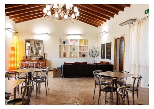 a room with tables and chairs and a couch at La Mora Bianca in Assemini