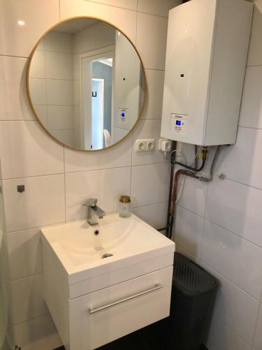 a bathroom with a sink and a mirror at Vakantiehuis Nynke in Grou