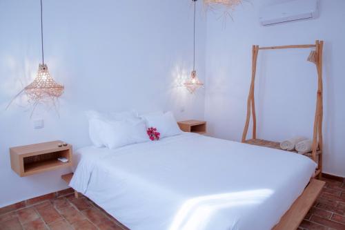 a white bedroom with a white bed and two lights at Mar-Ria 2 in Fuzeta