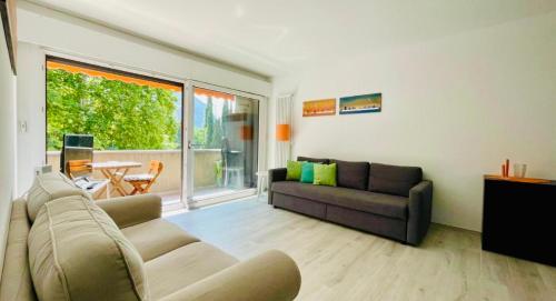 a living room with a couch and a table at Lugano Lakefront - Private Beach & Pool in Melano