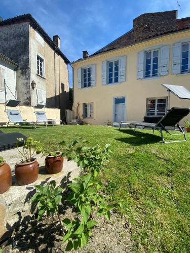 a house with a yard with chairs and plants at 2 pièces parking, plein centre au calme climatisé in Foix