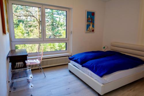 Un dormitorio con una cama y un escritorio y una ventana. en Lugano Lakefront - Private Beach & Pool, en Melano