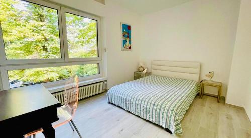 a bedroom with a bed and a desk and a piano at Lugano Lakefront - Private Beach & Pool in Melano