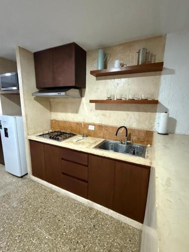 a small kitchen with a sink and a stove at Casa Ik 6 min AirPort 8 min Dowtown in Mérida