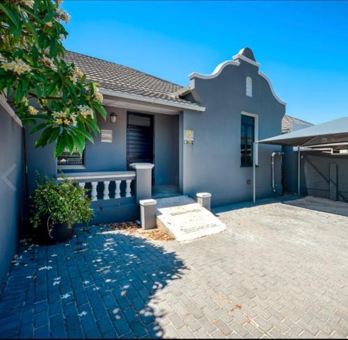 una casa azul con entrada de ladrillo en Strand Overnight - 24 Hour check-in - close to major private hospitals - sleeps 1- 4 guests - self catering - quiet neighborhood - week night low rate for single guest - weekends min 2 nights, en Strand