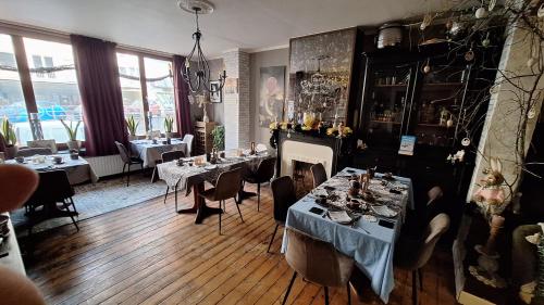 a restaurant with tables and chairs and a fireplace at "Chez Ba'Nus" in Blankenberge