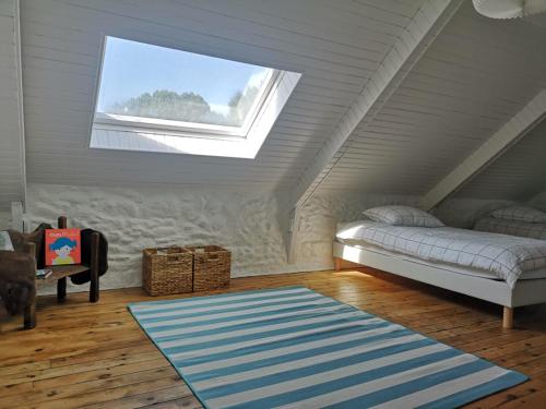 a attic room with a bed and a window at La Périgode - Magnifique demeure près des plages in Binic-Etables-sur-Mer