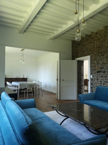 un salon avec un canapé bleu et une table dans l'établissement La Périgode - Magnifique demeure près des plages, à Binic