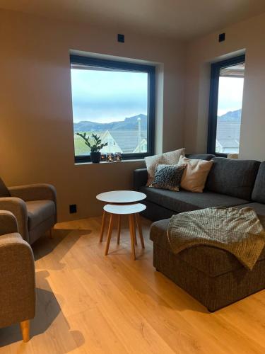 a living room with a couch and a table at Nybygd og sentral leilighet in Vestvågøya