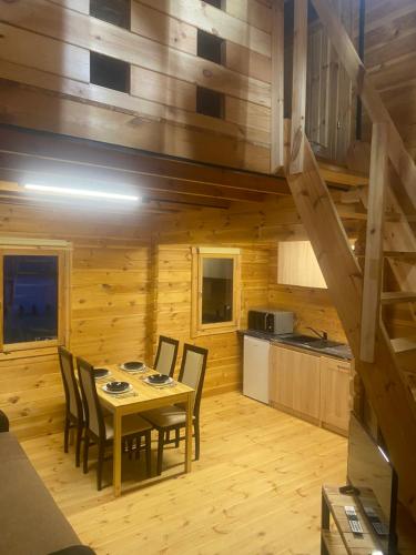 a kitchen and dining room with a table and chairs at Chatka na Górce 