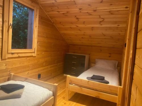 a room with two beds in a log cabin at Chatka na Górce in Okół