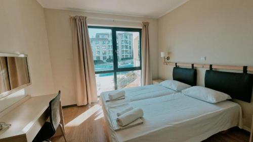 una camera da letto con due letti e una grande finestra di Byala Beach Resort a Byala
