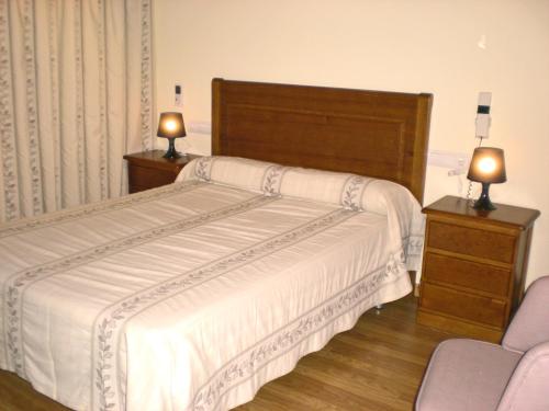 a bedroom with a bed and two lamps on night stands at Labella María in Pinos Genil