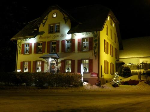 a large yellow building with lights on it at night at Hotel zum Kreuz in Sankt Peter