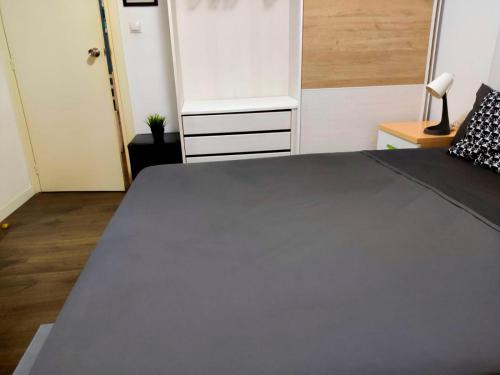 a bedroom with a large gray bed in a room at Hab Moderna A 20 Minutos del Centro de Barcelona in Santa Coloma de Gramanet