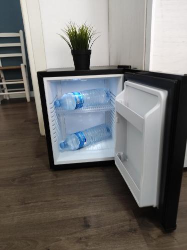 a refrigerator filled with bottles of water in it at Hab Moderna A 20 Minutos del Centro de Barcelona in Santa Coloma de Gramanet
