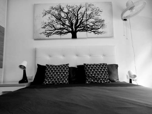 a black and white picture of a tree above a bed at Hab Moderna A 20 Minutos del Centro de Barcelona in Santa Coloma de Gramanet