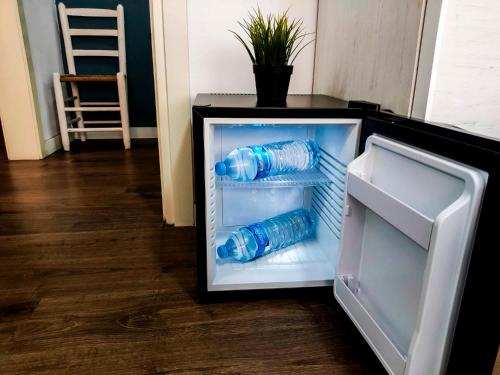 a refrigerator with two bottles of water in it at Hab Moderna A 20 Minutos del Centro de Barcelona in Santa Coloma de Gramanet