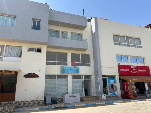 a large white building on a city street at Imi Waves Studio - Steps from Beach & Surf Spot, Imi ouaddar in Imi Ouaddar