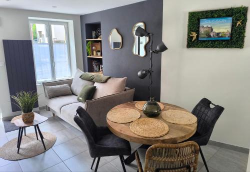a living room with a table and a couch at Le P'Tivoli - Maison centre historique in Clisson