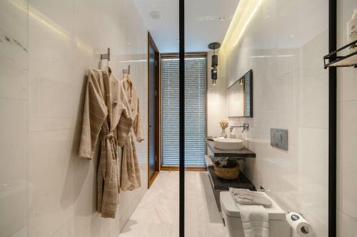 a white bathroom with a sink and a toilet at Voger Bodrum by The Sea in Yalıkavak