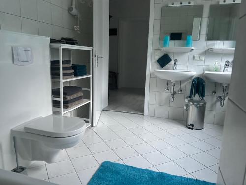 a white bathroom with a toilet and two sinks at Haus Edelweiss Panorama incl, Königscard in Nesselwang