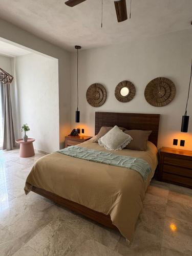 a bedroom with a bed and two mirrors on the wall at Villa Marena Hotel Boutique in Coyuca