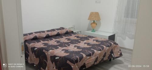 a bedroom with a bed and a lamp on a table at Appartamento vicino al mare in Praia a Mare