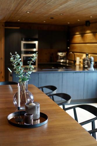 a wooden table with a vase with flowers in a kitchen at Exclusive Fjord Lodge with Private Jacuzzi and Epic Views in Lii