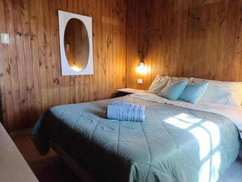 a bedroom with a large bed in a wooden wall at City Cabin in Uspallata