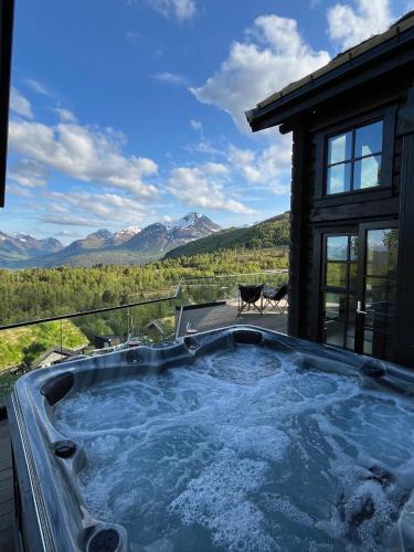 a jacuzzi tub on the deck of a house at Exclusive Fjord Lodge with Private Jacuzzi and Epic Views in Lii