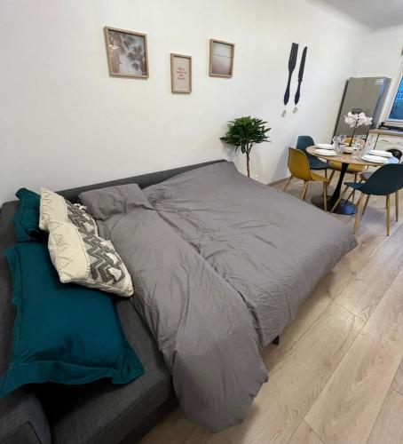 - un lit dans un salon avec une table dans l'établissement PARIS-MONTROUGE Magnifique Appartement 2 pièce de 36m2 - très cosy pour 1 à 5 personnes refait à neuf - ENTIRE APARTMENT LUXIRIOUS AND WARM - Montrouge Paris 14ème - Proche Aéroport Orly & Parc Expositions Porte de Versailles FREE WIFI GRATUIT, à Montrouge