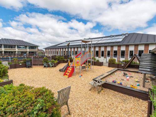a playground in front of a building with a building at 4 star holiday home in Fanø in Fanø
